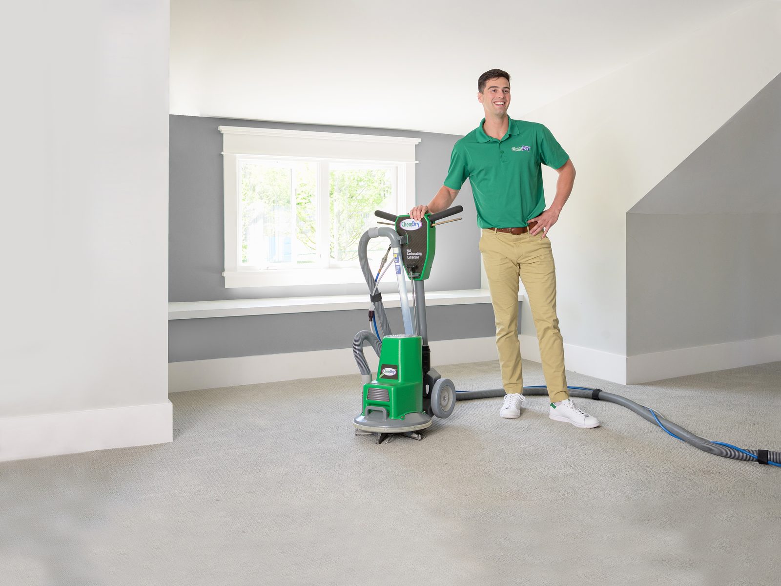Chem-Dry technician with a carpet extraction machine in a freshly cleaned room