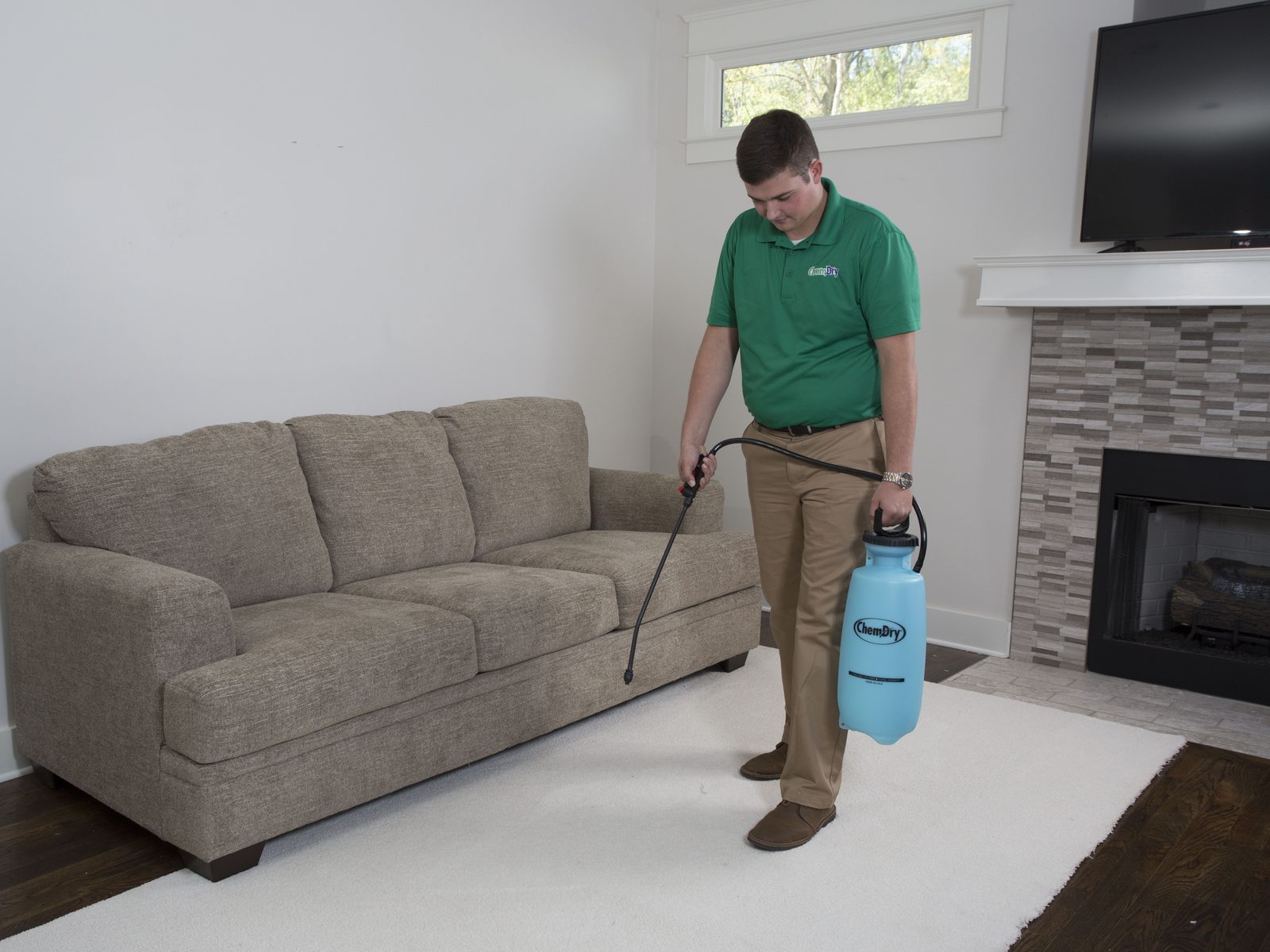 Chem-Dry technician pre-treating a rug in a living room